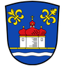 Ein Schild mit blauem Hintergrund, der eine Kirche mit roten Kuppeln und einem Kreuz darauf zeigt. Zwei Fleur-de-Lis-Symbole befinden sich an den Seiten. Die Basis des Schildes ist blau mit einer Wellenlinie.