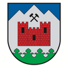 Ein Schild mit einer roten Burg und einem Hammer darüber, auf grünem und weißem Hintergrund.