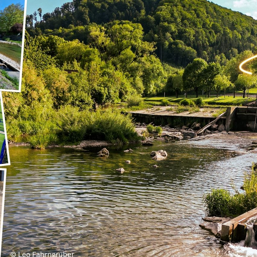 Ein ruhiger Fluss mit einem Berghintergrund, üppigen grünen Bäumen und Felsen. Das Wasser ist klar und fließt sanft. Fotografie von Leo Fahrngruber.