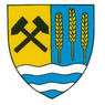 Ein Schild mit gelben und blauen Abschnitten, mit gekreuzten Hämmern im gelben Teil und Weizen im blauen Teil, alles auf einer wellenförmigen blau-weißen Basis.