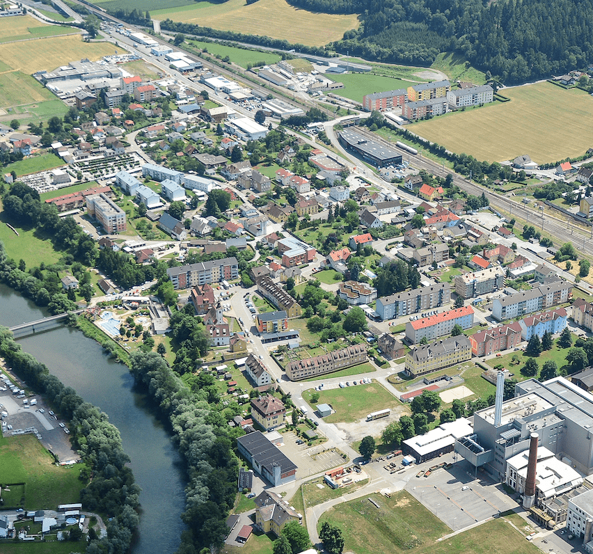 Luftaufnahme einer Stadt mit vielen Gebäuden und einem Fluss, der durch sie fließt.
