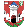 Das Wappen zeigt eine Burg mit drei Türmen, rotem Hintergrund und einem weißen Löwen auf einem grünen Schild. Es enthält Symbole wie ein schwarzes Tor, eine rote Fahne und ein blaues Dach.