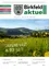 Plakat der Zeitschrift 'aktuell' für März 2023, das ein üppiges grünes Feld mit gelben Blumen und einem malerischen Dorf im Hintergrund zeigt.