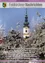 Ein hoher Kirchturm mit einer Uhr steht inmitten schneebedeckter Bäume. Das Bild enthält einen deutschen Bilduntertitel, möglicherweise aus einer Veröffentlichung der örtlichen Regierung.