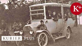 Ein altes Foto eines Oldtimer-Busses mit Menschen im Inneren und anderen, die draußen stehen, alle in Uniform und Hüten.