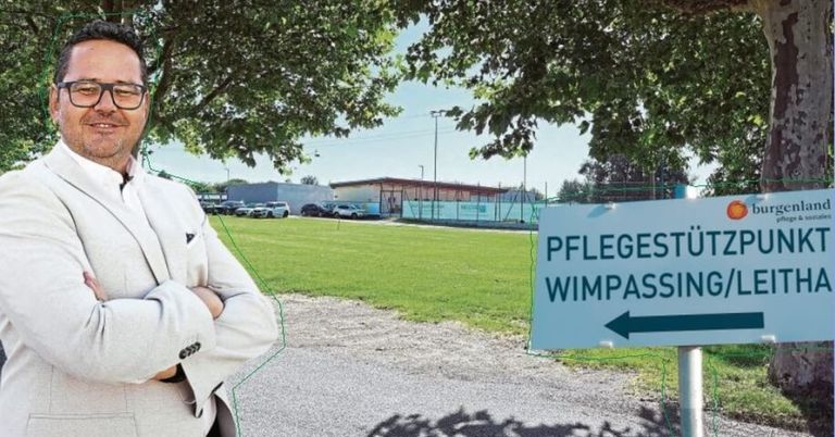 Eine Person in einem weißen Anzug steht neben einem Schild mit einem Pfeil nach rechts. Das Schild heißt Pflegest Wimpass. Hinter der Person befindet sich ein Feld mit geparkten Autos.