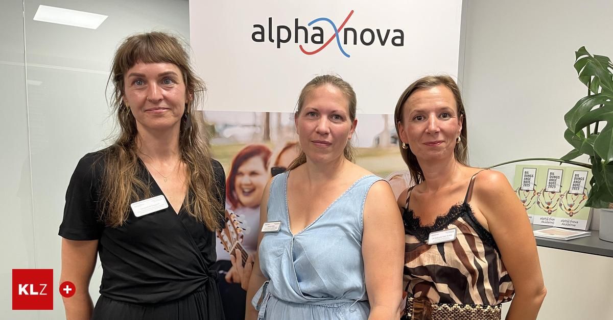 Drei Frauen posieren für ein Foto vor einem Alpha Nova-Schild. Eine hält eine Gitarre, alle tragen Namensschilder.