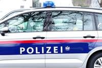 Ein weißer und blauer Polizeiwagen mit dem Wort 'POLIZEI' in Fettschrift auf der Seite. Das Fahrzeug hat einen roten und weißen Streifen entlang der Unterseite.