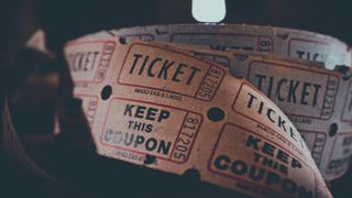 Ein Nahaufnahme von mehreren Tickets, von denen eines 'KEEP THIS COUPON' und 'TICKET' liest. Die Tickets scheinen alt und abgenutzt zu sein.