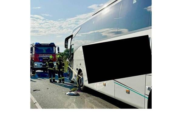 Ein Busunfall mit Rettungskräften am Straßenrand. Ein Feuerwehrwagen steht hinter dem Bus.