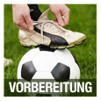 Ein Fuß in einem Fußballschuh tritt auf einen Fußball auf einem Rasenfeld, mit dem Wort 'Vorbereitung' darunter.