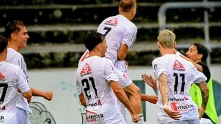Fußballspieler in weißen Trikots feiern ein Tor, einer trägt den anderen auf seinen Schultern. Der Spieler in der Mitte trägt die Nummer 21 und der Spieler auf der rechten Seite hat die Nummer 17.