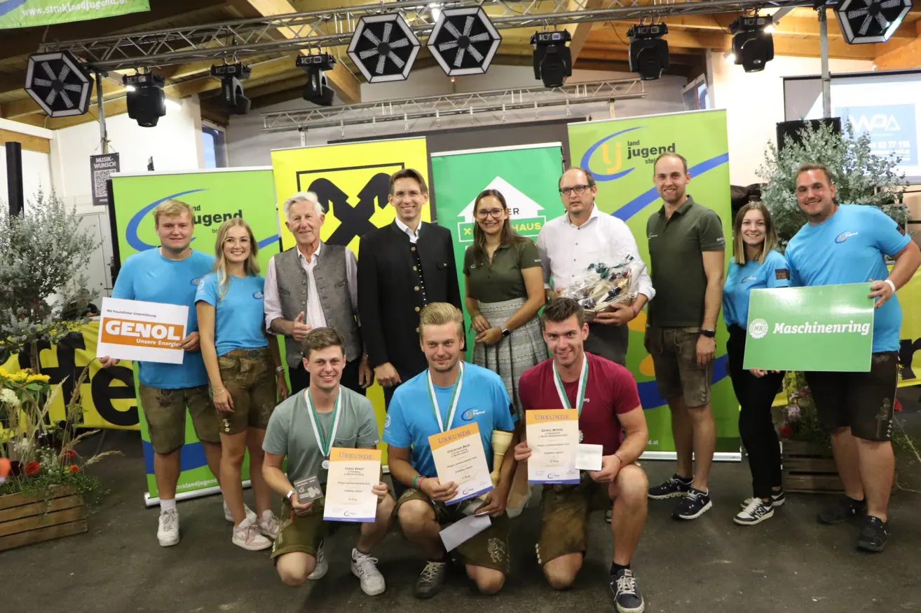 Eine Gruppe von Personen posiert für ein Foto und hält Urkunden in den Händen. Zwei von ihnen knien, und zwei andere stehen hinter ihnen. Sie tragen alle Medaillen um den Hals.