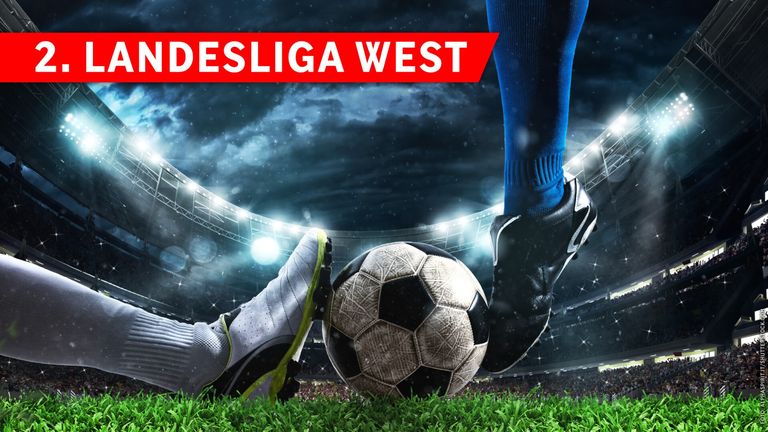 Ein Fußballspieler tritt einen Ball auf einem Feld, auf dem oben Desliga West steht. Der Spieler trägt blaue Socken und schwarze Schuhe.