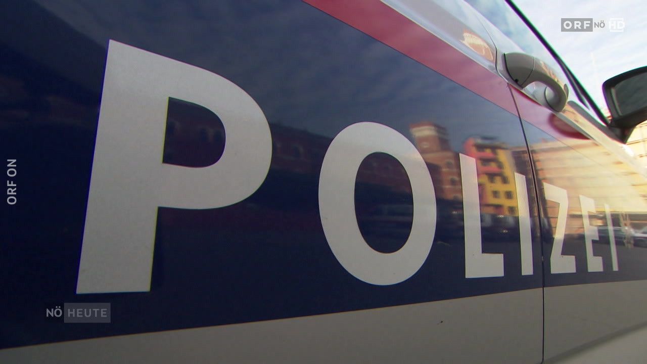 Eine Nahaufnahme eines Polizeifahrzeugs zeigt das Wort POL in großen weißen Buchstaben auf einem dunklen Hintergrund.