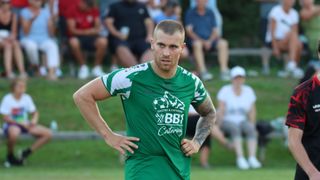Ein Fußballspieler in einem grünen Trikot mit dem Logo von BB1 Catering läuft auf dem Feld.