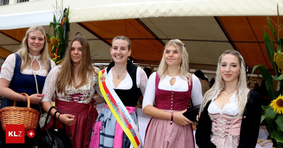 Vier Frauen in traditioneller Kleidung stehen unter einem Zelt und lächeln für die Kamera. Eine trägt eine Schärpe mit der Aufschrift 'JAV 2020'.
