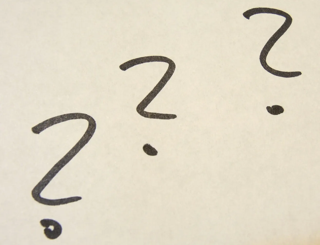 Ein Ausschnitt von handgeschriebenen mathematischen Symbolen, einschließlich eines Fragezeichens, einer 2 und eines Punktes.