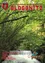 Ein Cover zeigt einen üppigen grünen Wald mit einem kleinen Wasserfall und einem gelben Gebäude im Hintergrund. Der Text 'GLOGGNITZ' ist oben in Rot großartig angezeigt.