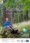 Ein älterer Mann sitzt auf einem mit Moos bedeckten Felsen im Wald. Er trägt eine Brille und eine blaue Jacke. Hinter ihm steht ein Baum mit dem Text Waldweg.