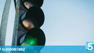 Eine Ampel mit grüner Ampel ist gegen einen klaren blauen Himmel beleuchtet. Die Ampel hat einen roten und gelben Kreis über der grünen Ampel.