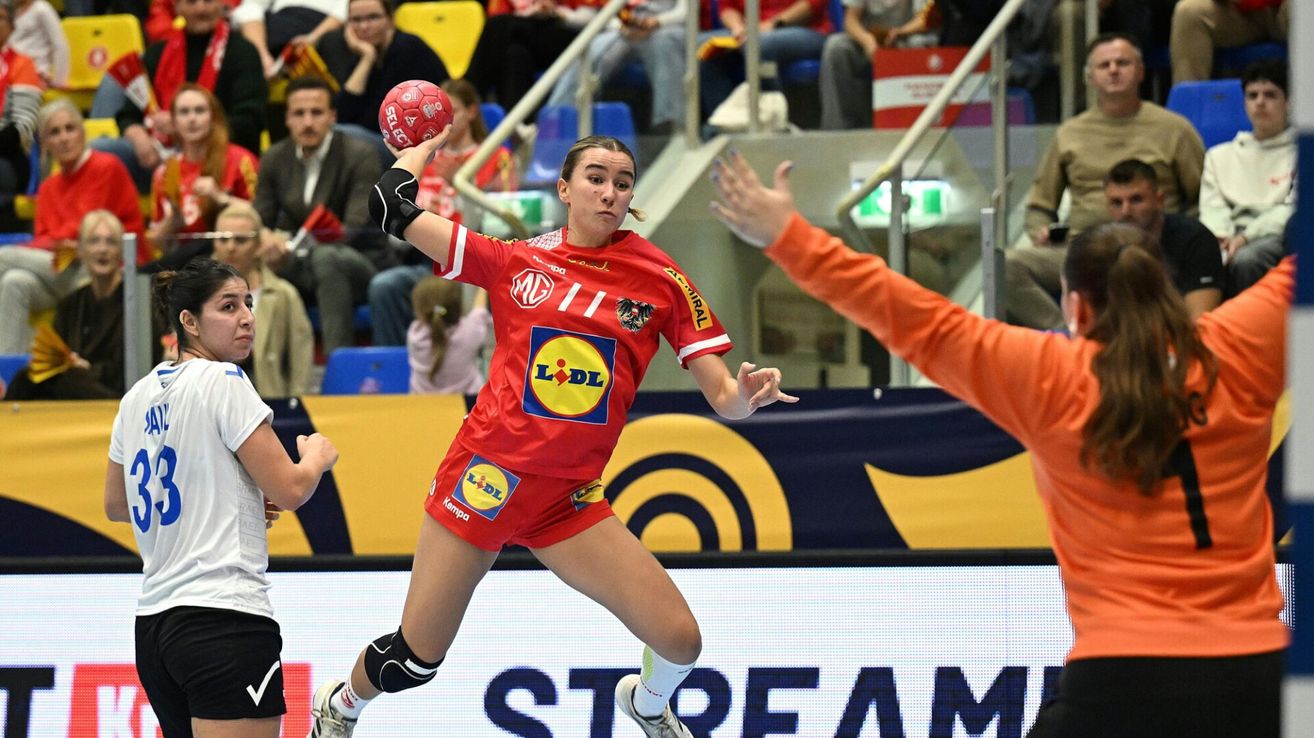 Eine Frau in einem roten Trikot mit L°DL-Logo spielt Handball und scheint den Ball zu werfen.