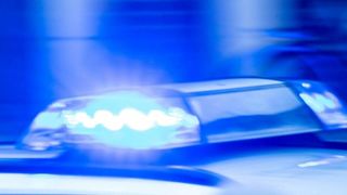 Nahaufnahme der blinkenden blauen Polizeilichter. Das Licht ist gegen einen dunkelblauen Hintergrund beleuchtet.