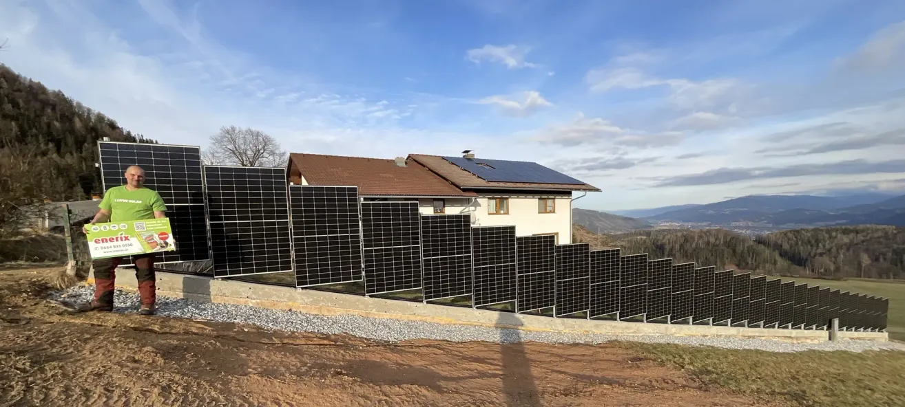 A house with solar panels on the roof and along the wall on a sunny day.