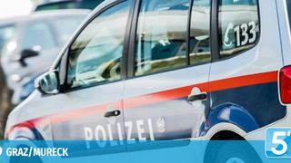 A police car with the word Polizei on the side and a red and white stripe on the door.