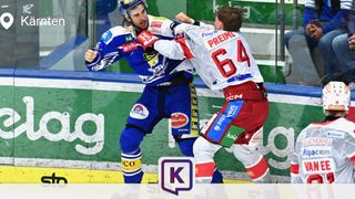 Two hockey players are fighting on the ice rink. One is wearing a blue uniform, and the other is in a red uniform. They are both wearing helmets and gloves.
