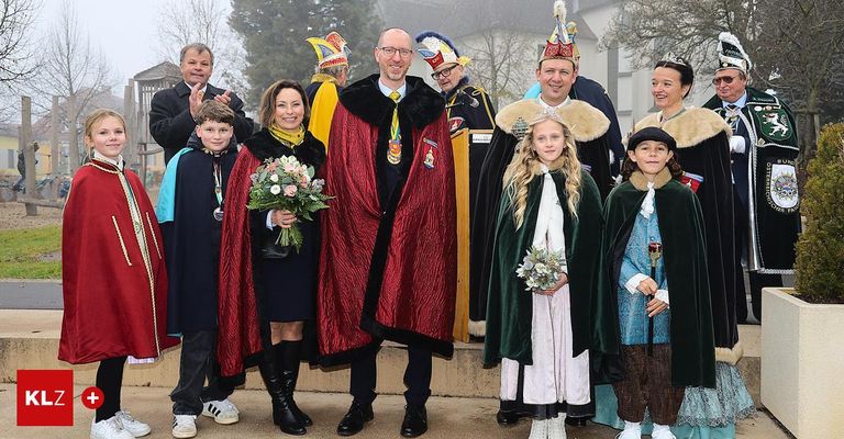 Eine Gruppe von Menschen in verschiedenen Kostümen, einige mit Kronen, posiert für ein Foto.