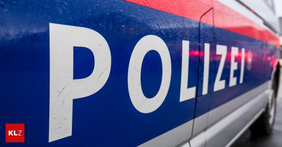 Ein Nahaufnahme eines Polizeifahrzeugs mit dem Wort 'POLIZEI' auf der Seite, das Regentropfen reflektiert.