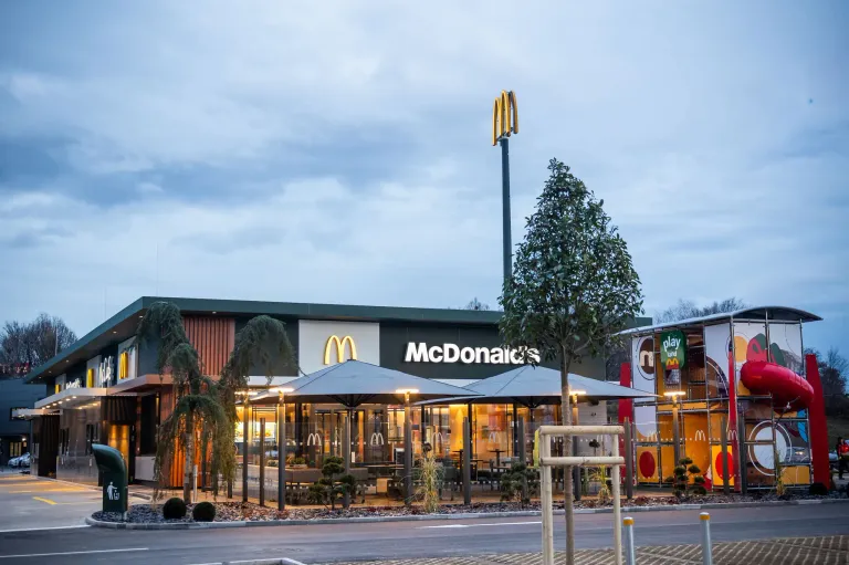 Das Äußere eines McDonald's-Restaurants mit dem ikonischen goldenen M-Schild, vor einem Gebäude mit modernem Design.