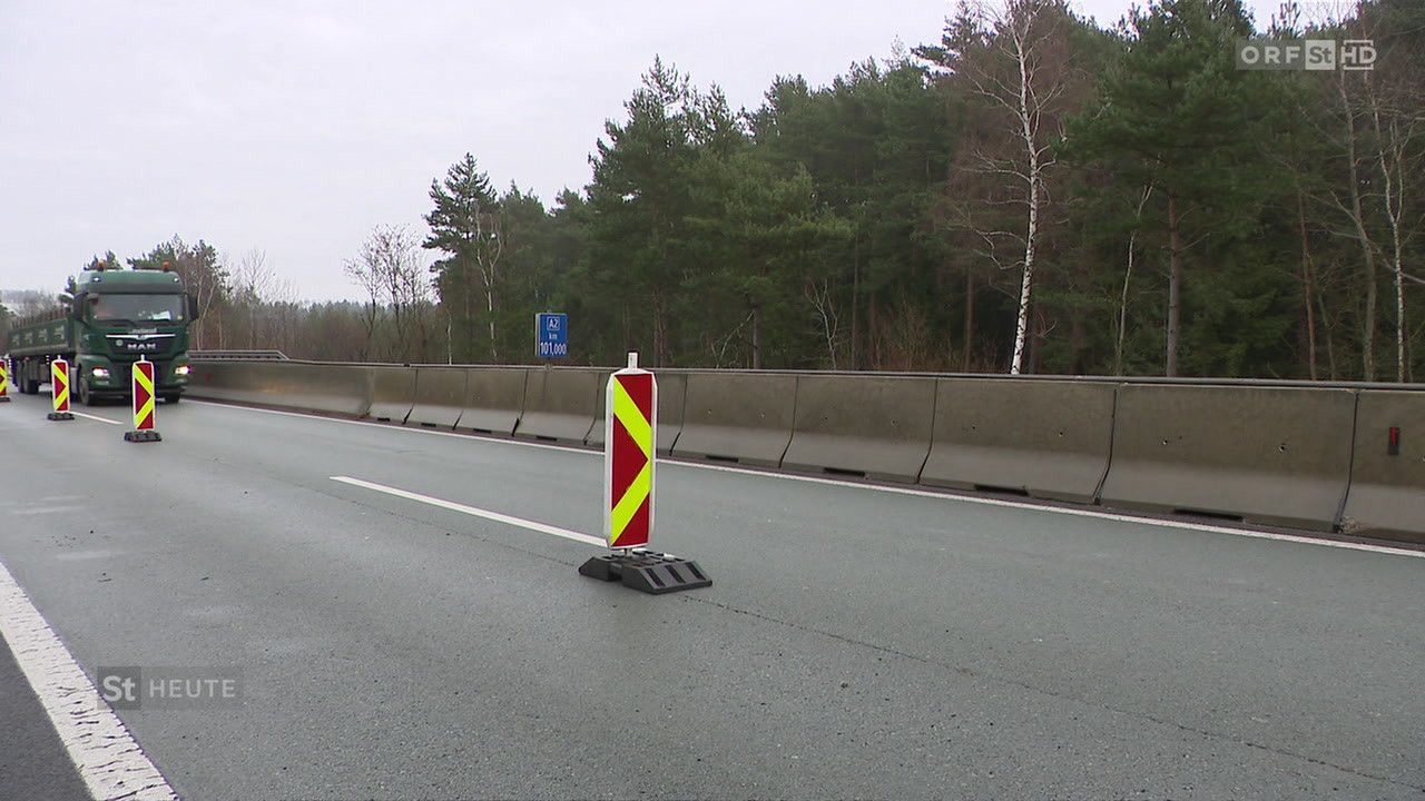 Eine leere Autobahn mit einer Barriere an der Seite und einem blauen Schild, das eine Grenze von 101.000 anzeigt.