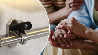 Eine Nahaufnahme einer schwarzen Kamera, die an einem silbernen Handlauf montiert ist. Daneben hält ein Paar Händchen, beide tragen Ringe. Der Mann hat ein gestreiftes Hemd.