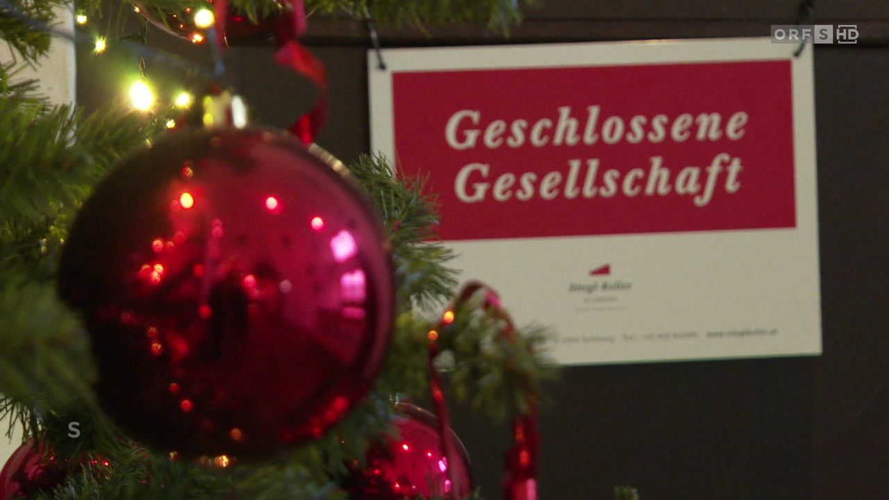 Ein Nahaufnahme eines roten Weihnachtskugels mit einem Schild im Hintergrund, das 'Geschlossener Gesellschag' steht.
