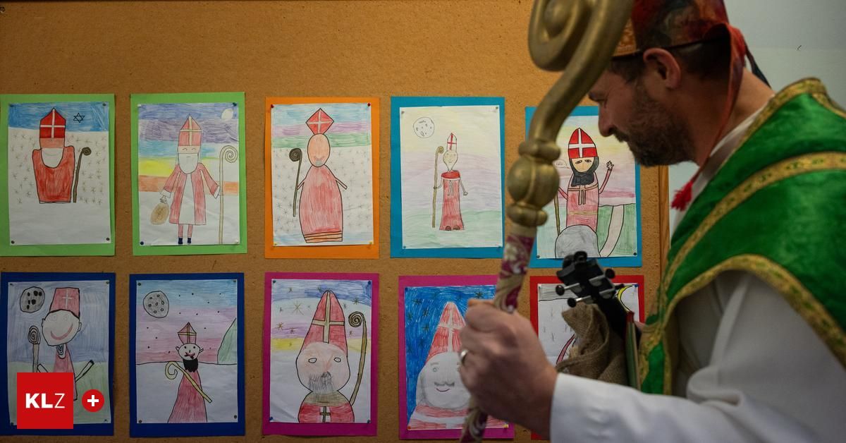 Ein Priester betrachtet Kinderzeichnungen von Heiligen an einer Wand, jede in verschiedenen Farben gerahmt.
