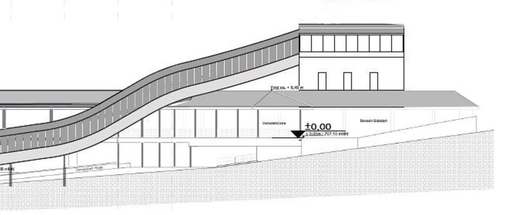 Das Bild zeigt eine Seitenansicht eines Gebäudes mit einem geneigten Dach, Fenstern und einer Rampe. Es gibt einen Höhenunterschied von +0,00 Metern. Das Gebäude hat ein Flachdach und einen geneigten Eingang.
