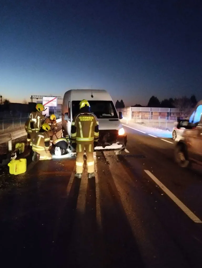 Feuerwehrleute in gelber Uniform kümmern sich um eine verletzte Person in der Nähe eines Vans auf einer Straße bei Nacht.