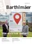 Zeitschriftencover mit zwei Männern neben einem Schild. Das Schild trägt 'Hier' mit einem roten Standort-Pin. Der Titel lautet 'Barthlmaer'. Das Cover hat einen QR-Code.