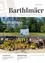 Eine Gruppe von Kindern und Erwachsenen versammelt sich auf einer Baustelle. Ein Schild sagt 'Startschuss' und ein Banner ist im Hintergrund zu sehen. Die Kinder tragen gelbe Helme und halten Schaufeln.