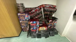 A variety of fireworks displayed in a room, including Dragon, Rocket, and Max series, stacked in boxes on the floor.