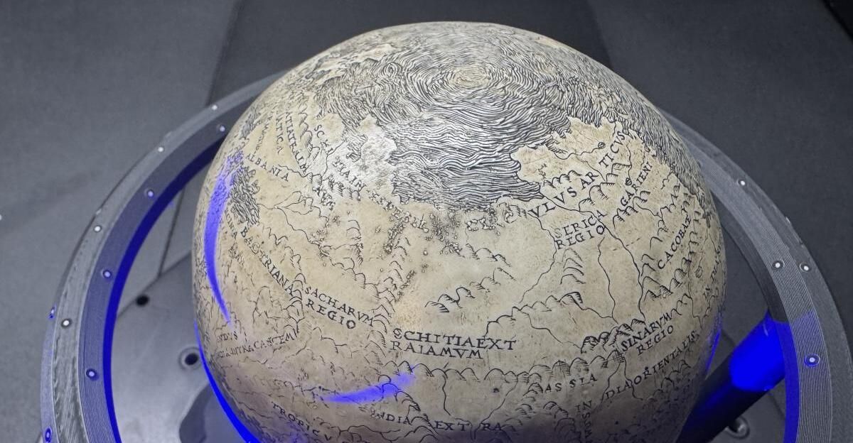 Ein antiker Globus wird ausgestellt und zeigt detaillierte geografische Merkmale mit lateinischen Inschriften. Bemerkenswerte Regionen sind Skythien und Tartarien.