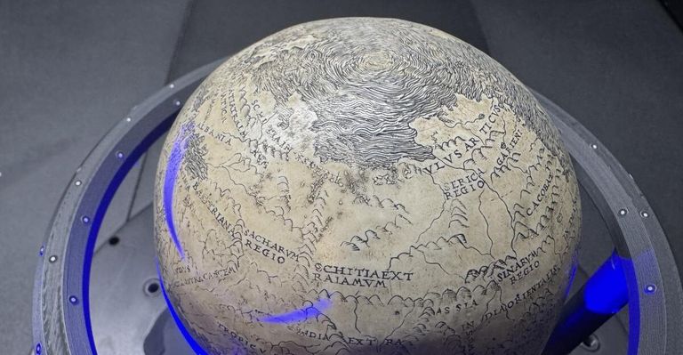 Ein antiker Globus wird ausgestellt und zeigt detaillierte geografische Merkmale mit lateinischen Inschriften. Bemerkenswerte Regionen sind Skythien und Tartarien.