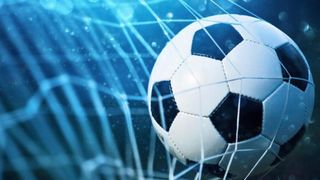 Ein Fußball ist im Netz mit blauem Hintergrund und Wassertropfen. Der Ball ist weiß und schwarz mit einem Fünfeckmuster.