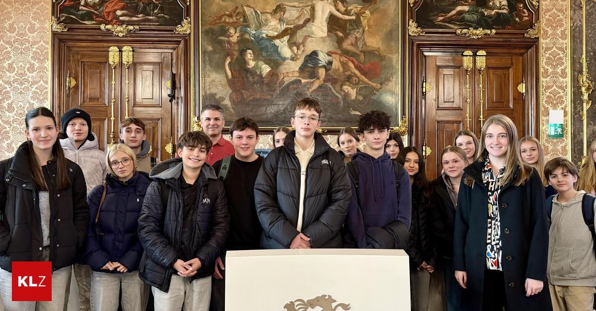 Eine Gruppe von Schülern steht vor einem Podium in einem Raum mit historischen Gemälden an den Wänden.