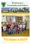 Eine Gruppe von Kindern in einem Klassenzimmer mit zwei Erwachsenen, die vor einer Pinnwand mit Kürbissen stehen.