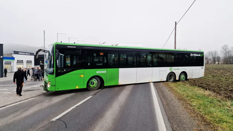 Ein grüner und weißer Bus steht am Straßenrand. Auf der Vorderseite befindet sich ein digitales Display, das die Nummer 500 anzeigt.