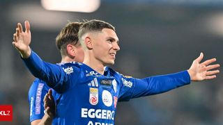 Ein Fußballspieler in einem blauen Trikot mit dem Wort Eggero feiert ein Tor. Ein weiterer Spieler im Hintergrund trägt ebenfalls ein blaues Trikot.