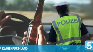 Ein Polizeibeamter überprüft einen Fahrer, der eine Bierflasche hält, mit einem unscharfen Hintergrund, der ein Auto und ein Logo zeigt.